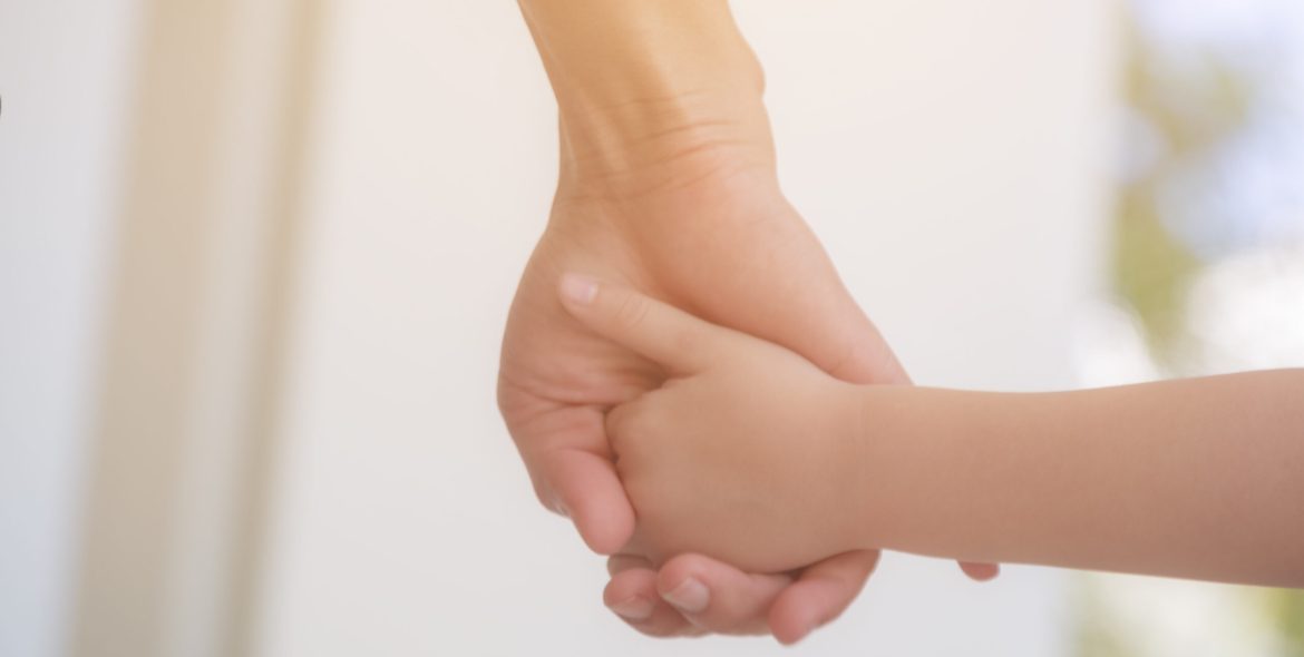 close-up-mother-holding-hand-child-home